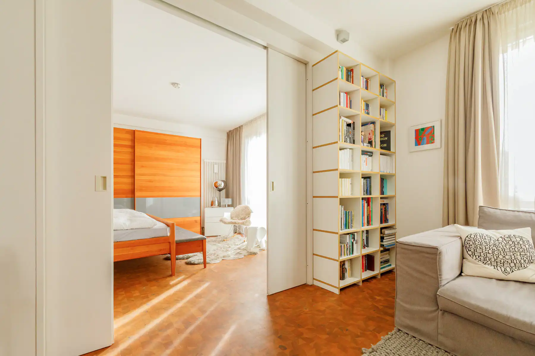 Helles Wohnzimmer mit Bücherregal und Blick ins Schlafzimmer in Stuttgart.