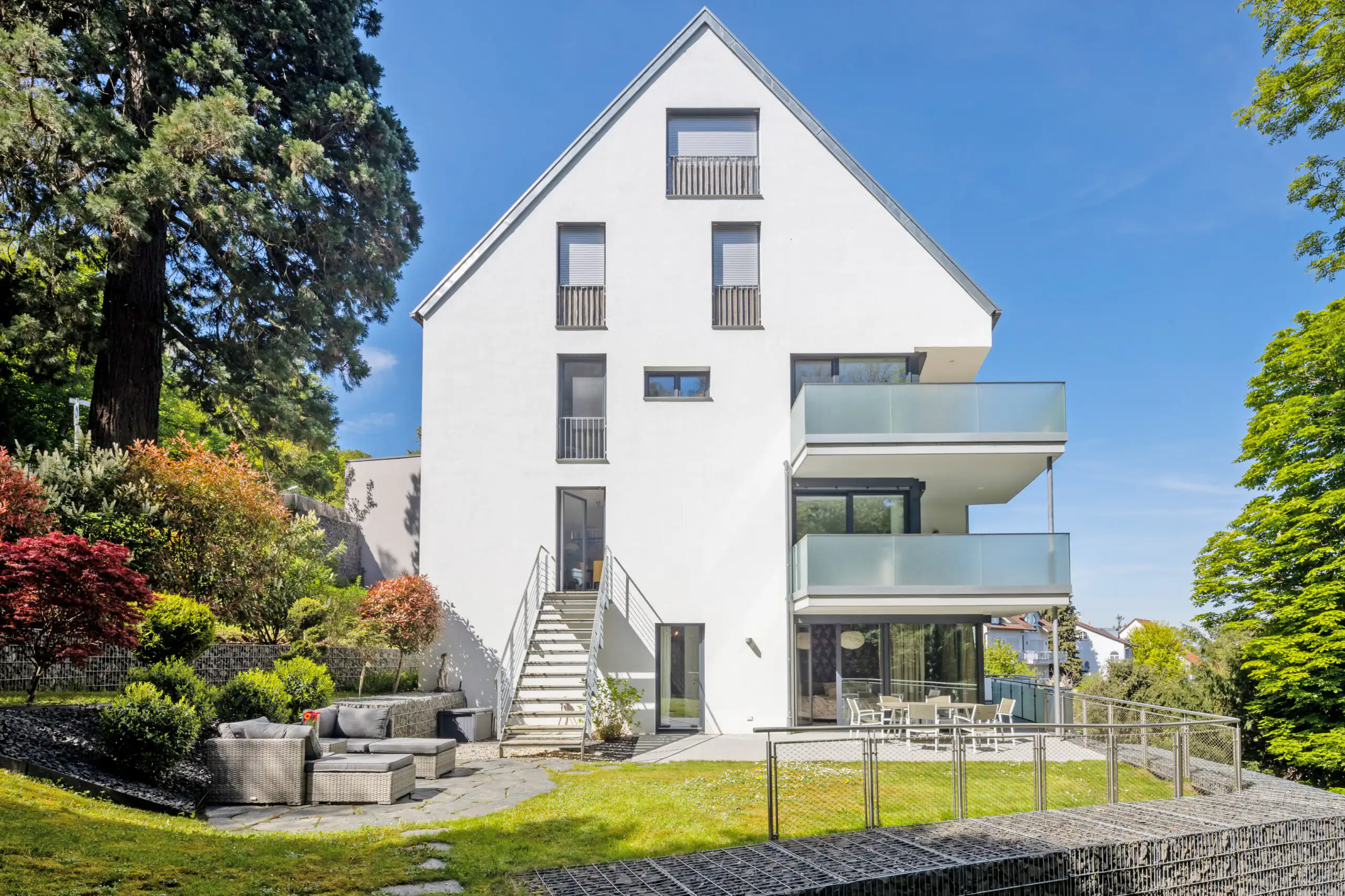 Modernes weißes Mehrfamilienhaus mit Balkon und Garten in Stuttgart.